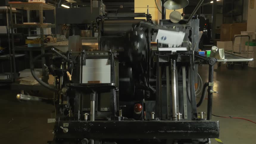 A machine is printing and stacking paper
