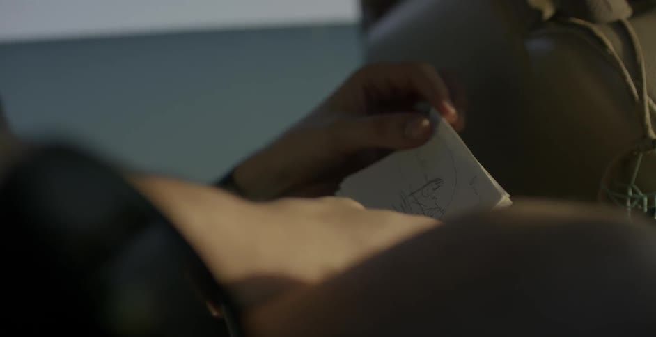 Person sitting down flips through small squares of paper