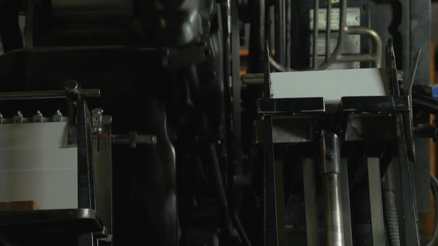 A machine flips white cards from one section to the next