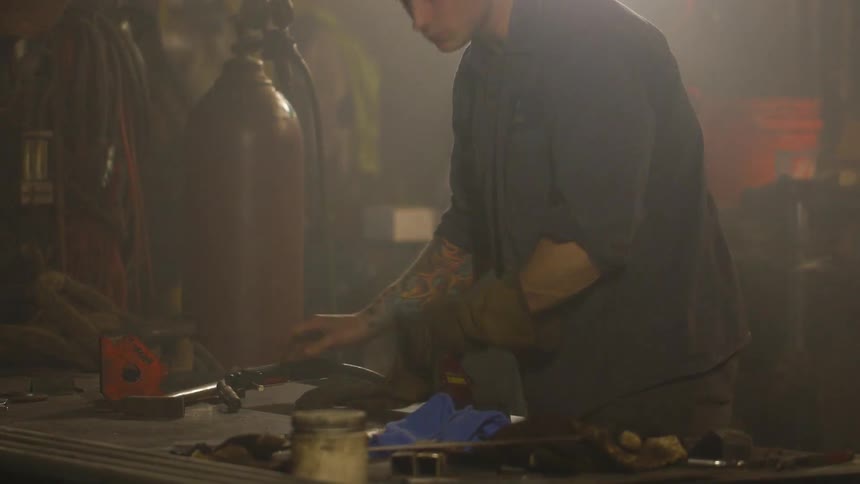 A man welding something on a table on a bench