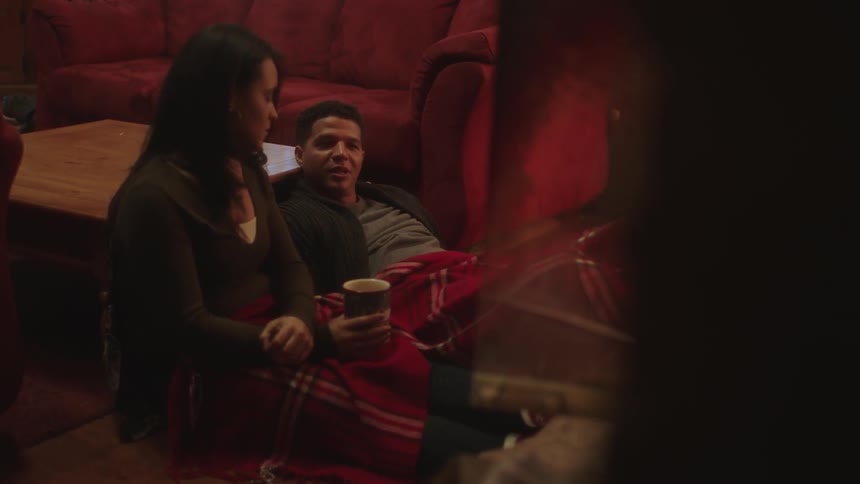 A man and a woman talk while sharing a blanket