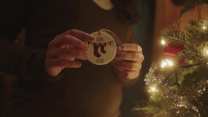 A woman shows a white ornament with a string attached