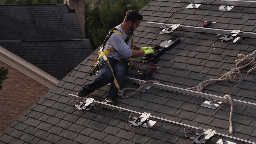 A man is working on installing a solar system on a rooftop