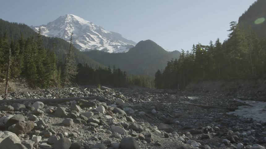 Reveal of Mount Rainier from a snow melt river valley