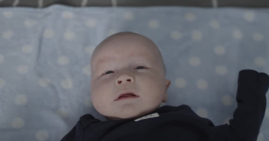A baby cries while laying on its back