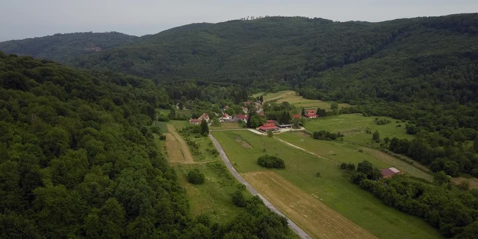 The tree covered hills have a small town in the middle