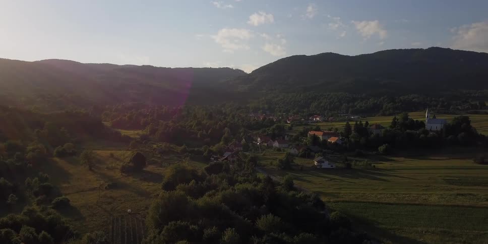 Sun rising over mountains and a small village