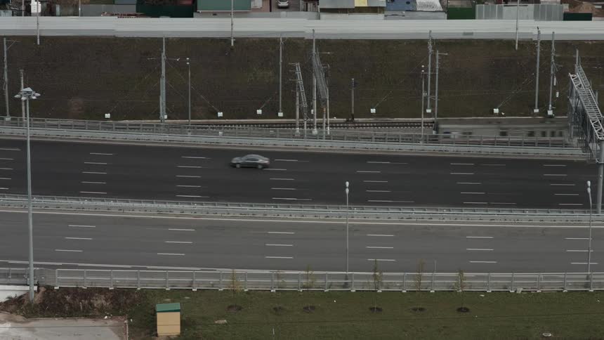Cars race back and forth on the highway below