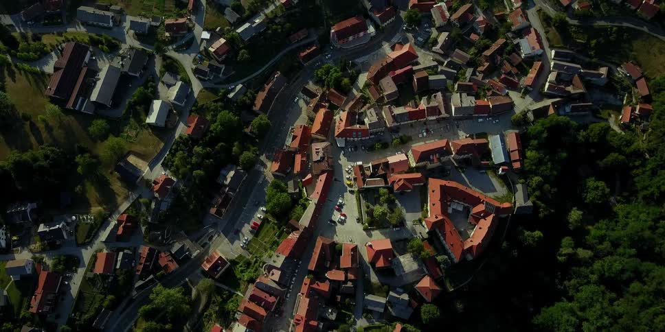 The row of houses are on a hill with trees on the side