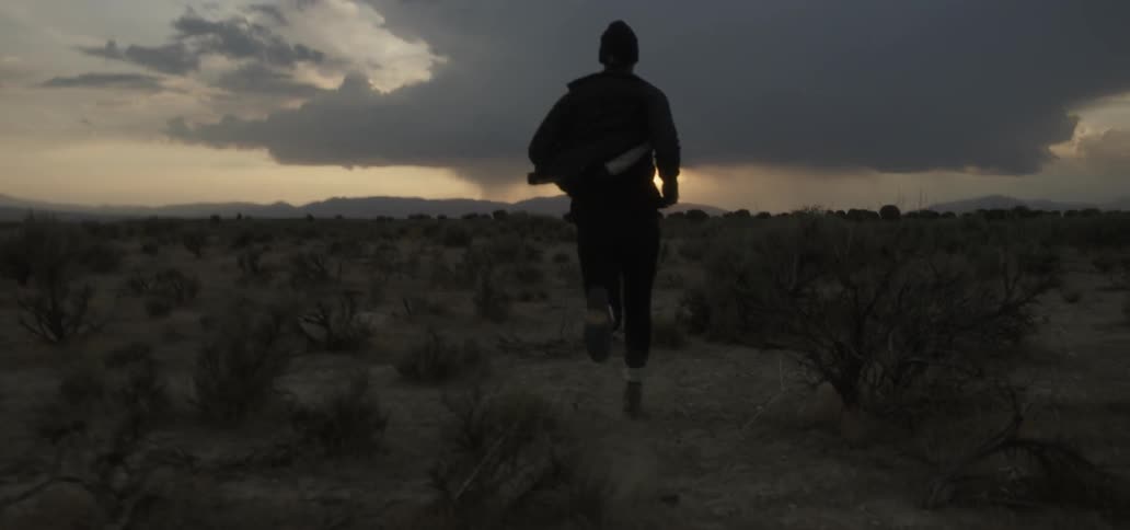 A man is running down the desert at dawn