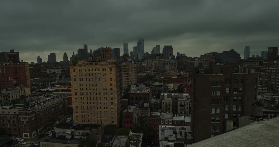 Dark clouds move over a city as dusk falls