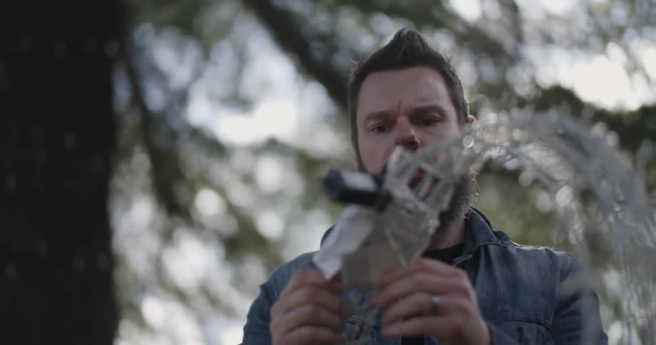 A man sets up christmas lights in the front yard