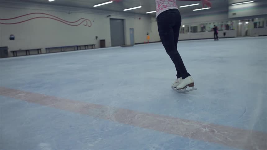 An ice skater twirls around on an ice rink
