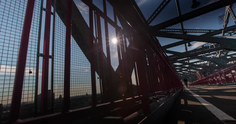 Pedestrians and bicyclists cross a city bridge