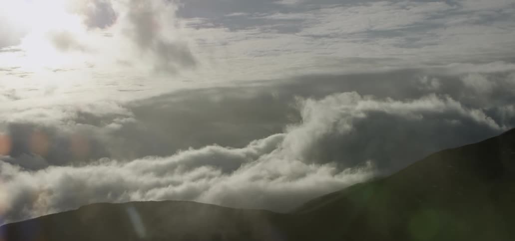 Clouds swirling over rolling hills