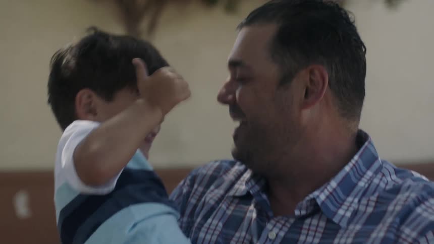 A man holding his son hugs him