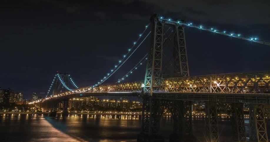 A bright, busy bridge at night