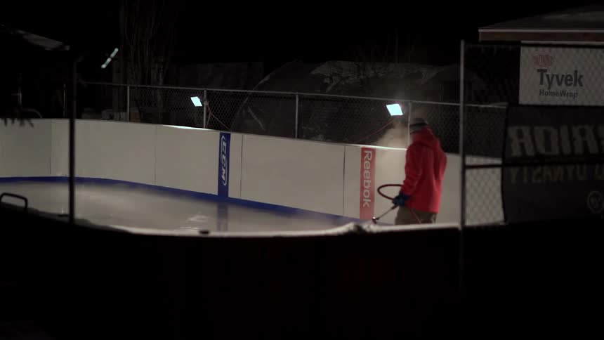 A man is cleaning up an ice rink