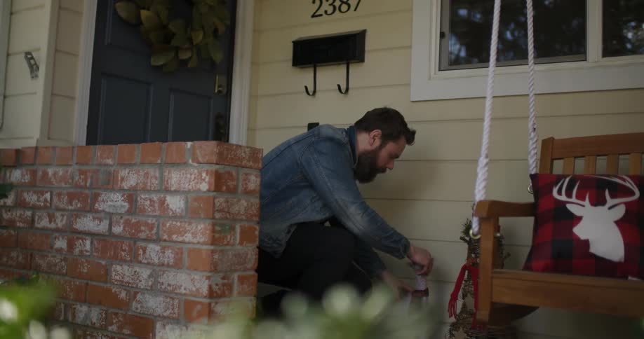 A man drops an ornament near the front of his home