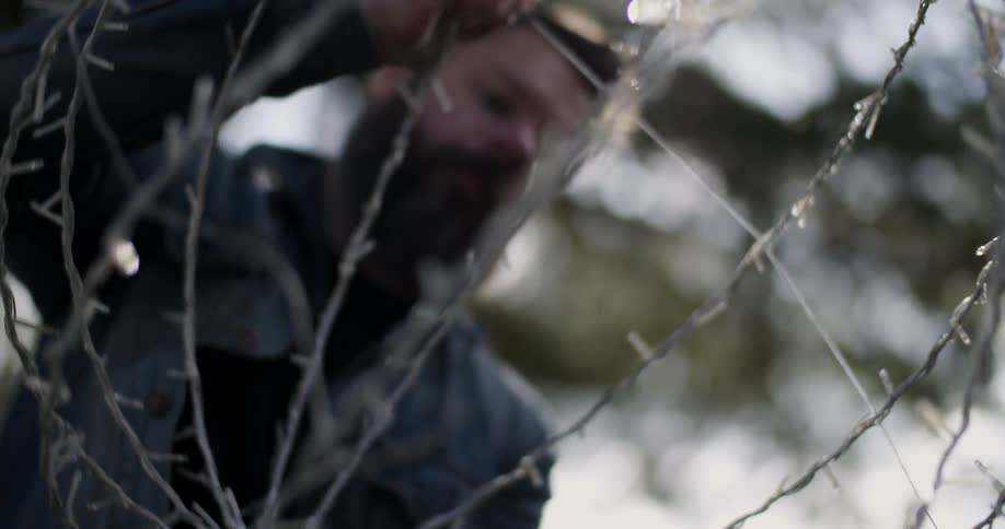 A man is adjusting wires on a metal decorative cage