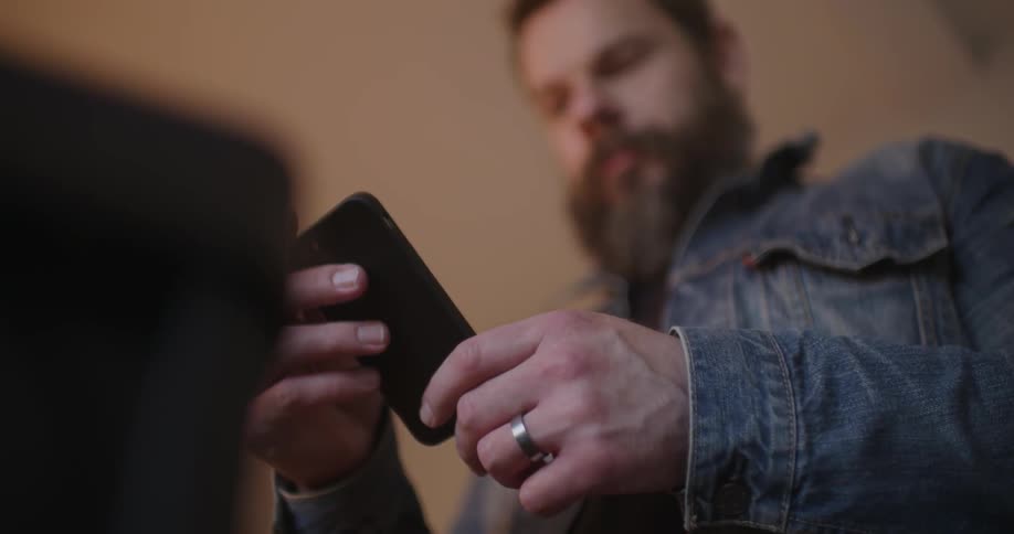 A man is using his cellphone then puts it away