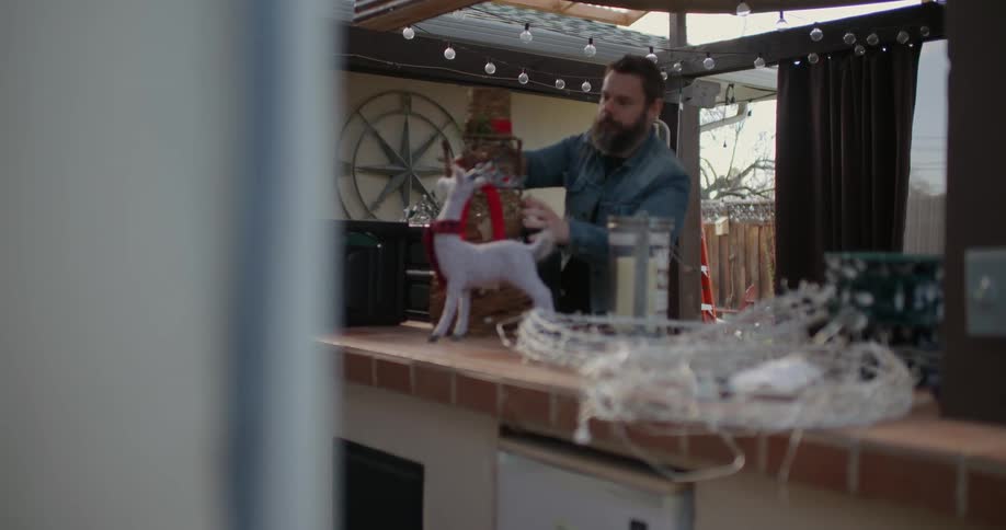 A man is setting a box down on counter strewn with decorations