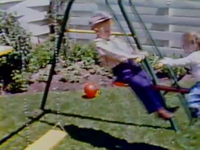 Two children swinging on teeter totter swing