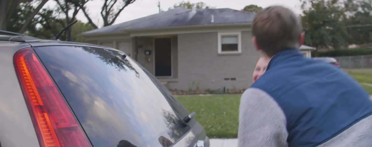 A man and woman laugh as they close the trunk on the suv
