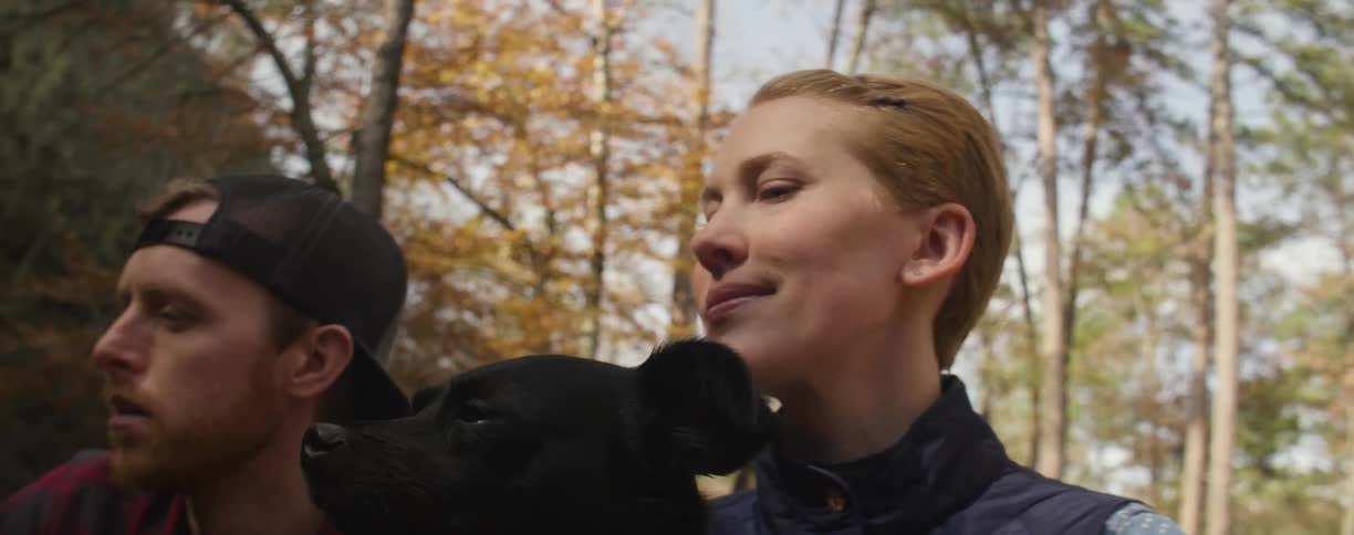 Man woman and dog looking out into the woods