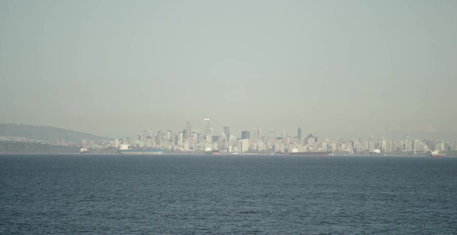 View of a city skyline and some mountains from a boat on the ocean