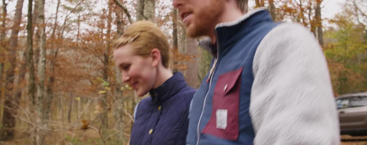 Couple walking and talking through the woods on a fall day