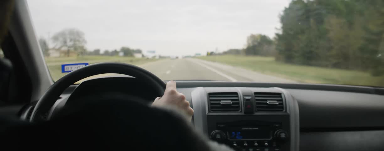 A person is driving down a long road