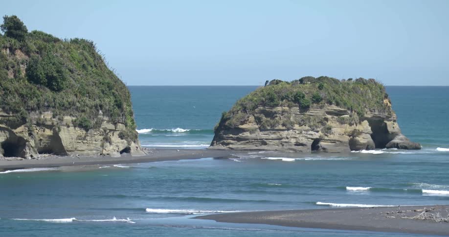 Waves come to shore around a rock island