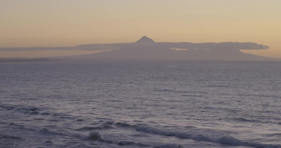 Waves gently crash on the beach at dusk