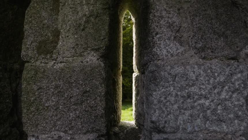 Sun shines through a crack between a stone structure