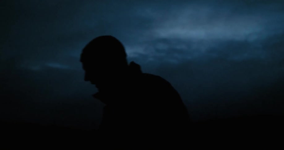 A man walks at night in the dark