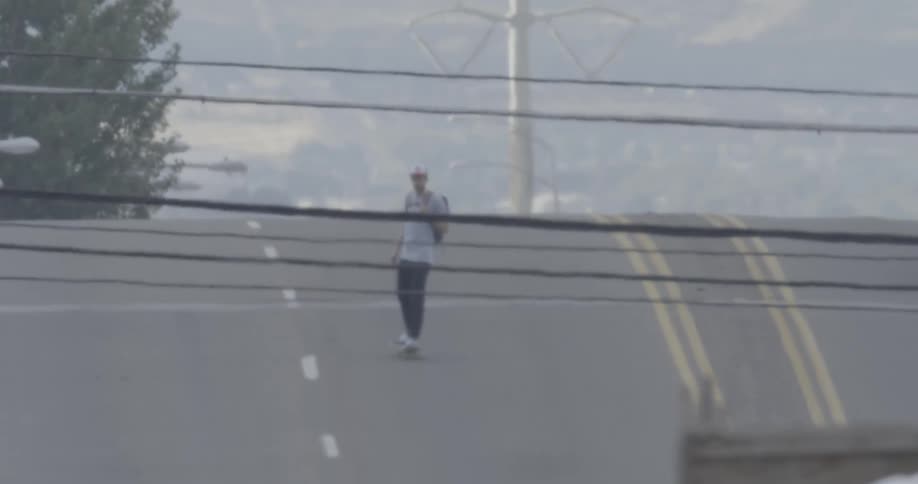 Man skateboarding quickly down a sloping road
