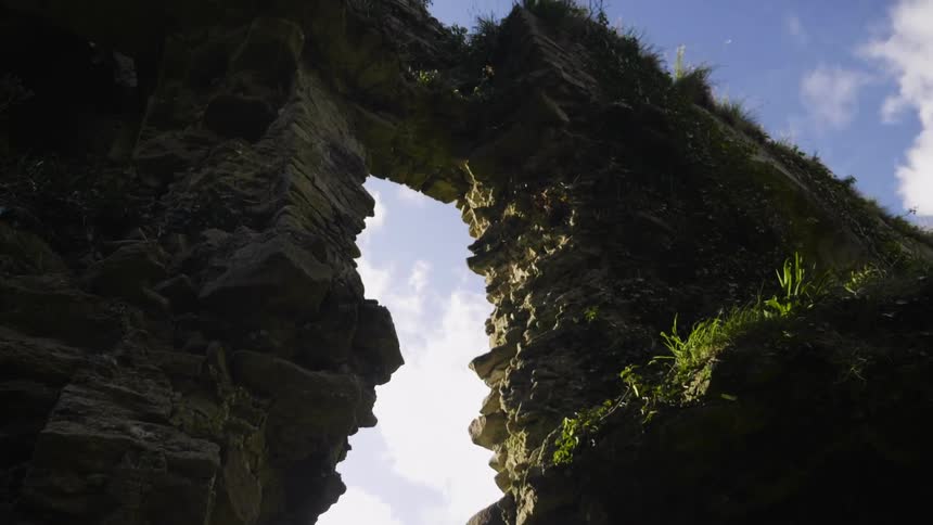 A view of a large rock with a walkway through the middle of it