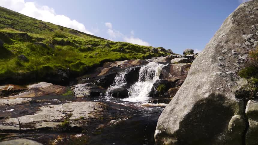 Small waterfall splashing into a rocky stream