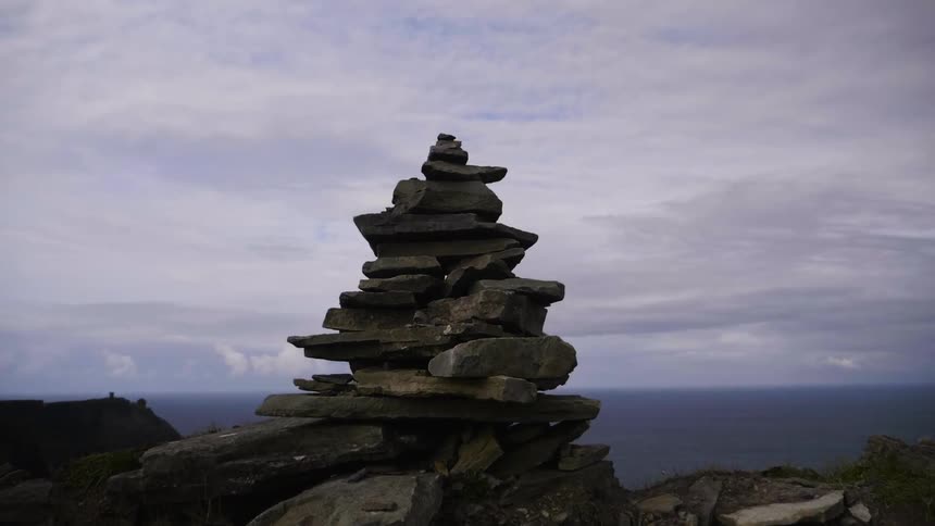 A balanced pile of rocks near a large body of water
