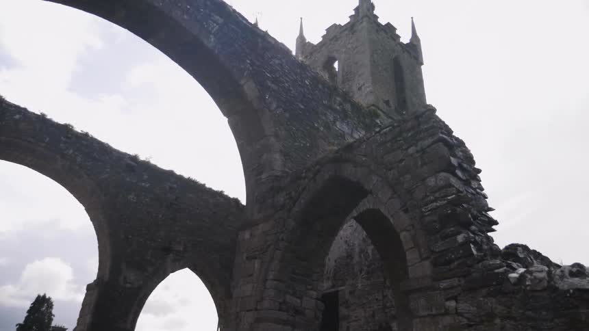A stone tower sits high in the cloudy sky