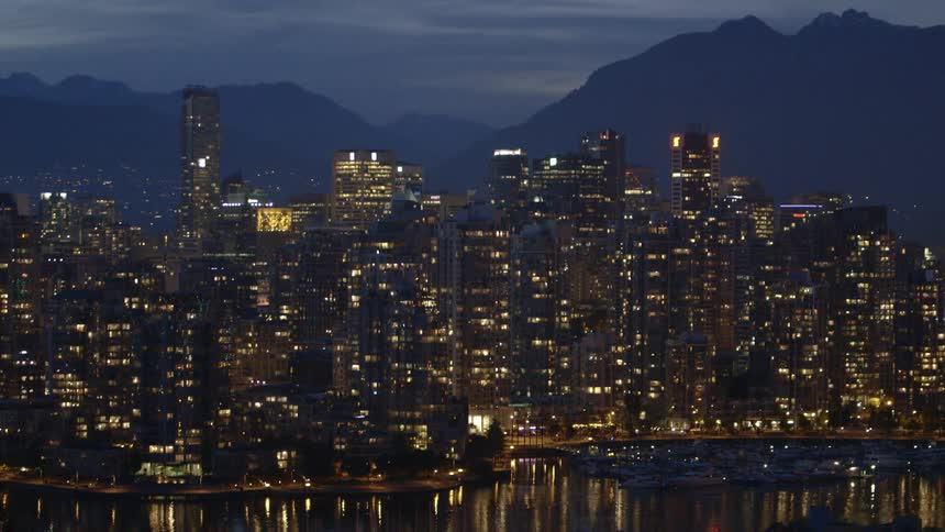 City building towering over a river at night