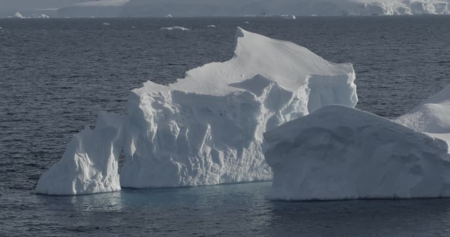 Calm water ripples around an iceberg