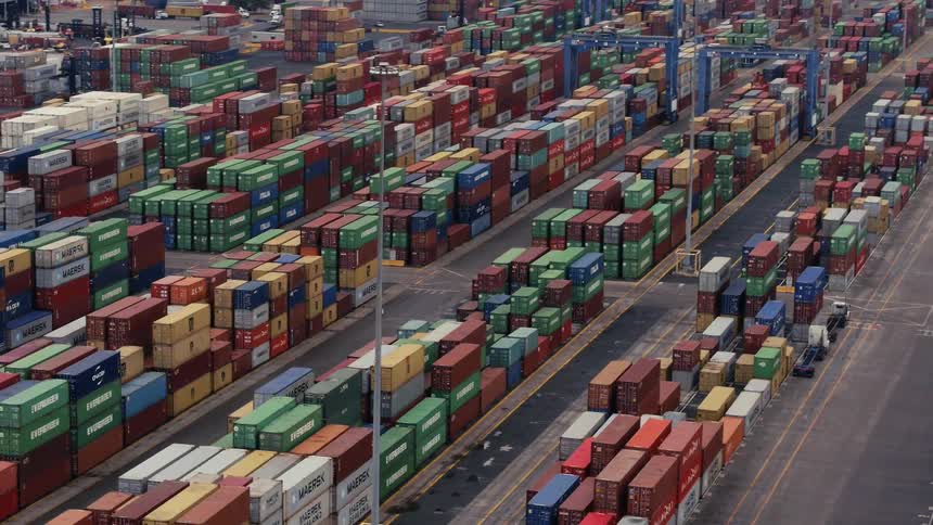A dock has many containers all stacked together