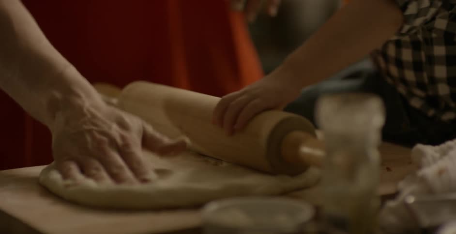 A child helps rolling some dough