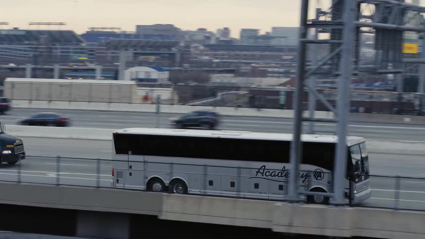 A bus drives on a city highway