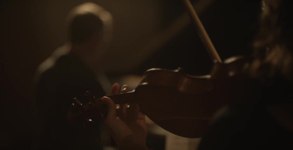 Man playing a piano and a person plays the violin