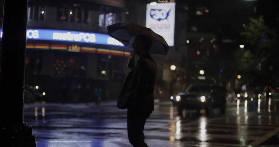 A man using an umbrella near the street