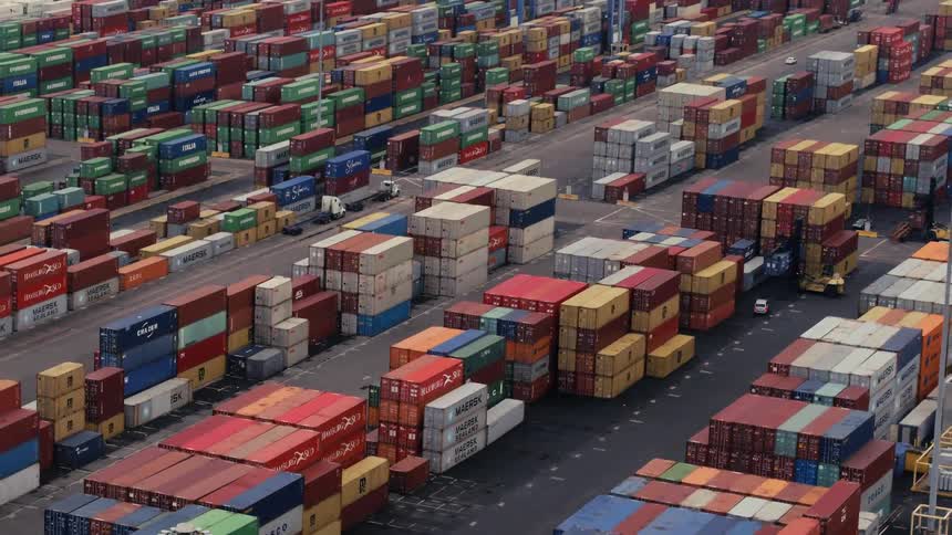 Different colored boxes stacked on a vast area of pavement