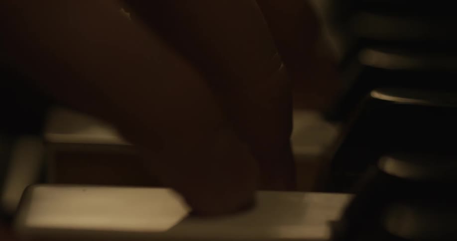 The white keys of the piano are slowly pressed